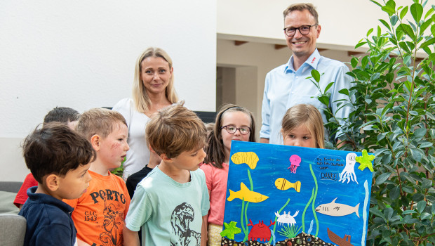 Kita-Leiterin Katharina Billmann und die Kinder bedanken sich für die Spende bei Sera-Pressesprecher Oliver Helker mit einem selbstgebastelten Bild eines Aquariums.