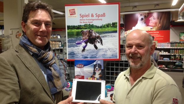 Canina-Gebietsverkaufsleiter Volker Zachow (links) überreicht Helmut Bross sein neues“ iPad Mini“.