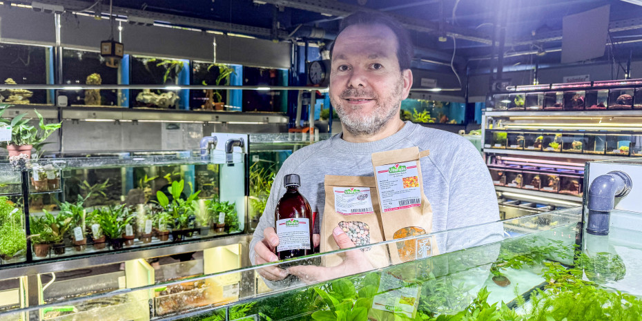 Thomas Strecker mit einigen  Eigenmarke-Produkten in der großen Aquaristikabteilung.